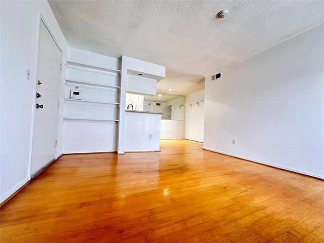 260 El Dorado Blvd Unit 2608, Houston, TX 77598 - unfurnished living room featuring light wood finished floors and a textured ceiling