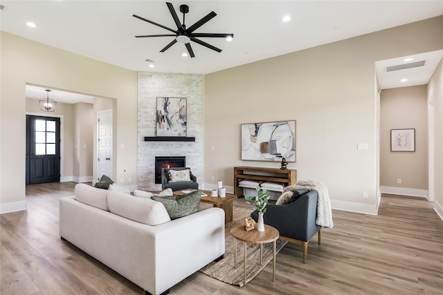 1430 Bluebonnet Ridge Dr, Chappell Hill, TX 77426 - living room featuring a stone fireplace, wood finished floors, ceiling fan, and recessed lighting