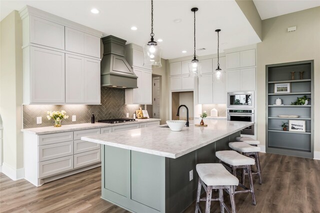 1430 Bluebonnet Ridge Dr, Chappell Hill, TX 77426 - kitchen with premium range hood, appliances with stainless steel finishes, wood finished floors, decorative backsplash, and recessed lighting