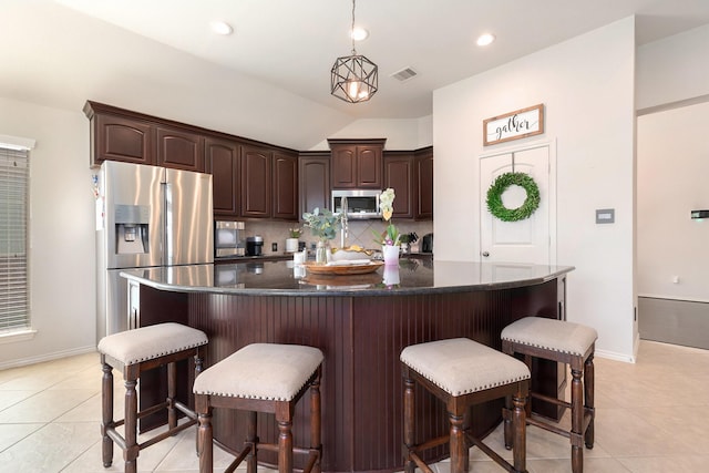 14730 Yellow Begonia Dr, Cypress, TX 77433 - kitchen with appliances with stainless steel finishes, tasteful backsplash, dark brown cabinets, light tile patterned floors, and vaulted ceiling