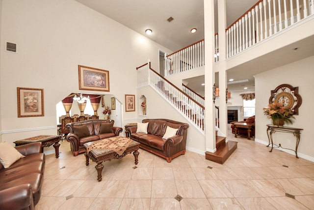 20718 Mansfield Bay Ln, Richmond, TX 77407 - living room with a high ceiling, stairs, a fireplace, tile patterned floors, and recessed lighting