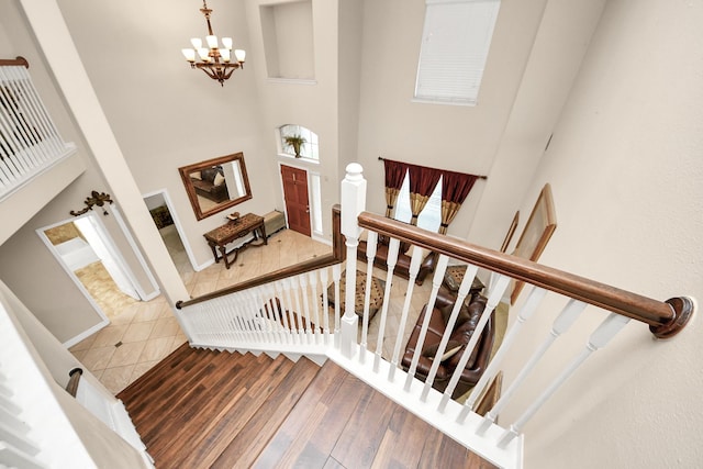 20718 Mansfield Bay Ln, Richmond, TX 77407 - stairway featuring a towering ceiling, a chandelier, and wood finished floors