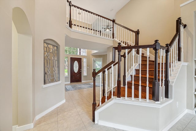 17426 Little Riata Dr, Houston, TX 77095 - foyer featuring a towering ceiling, arched walkways, tile patterned floors, and stairway