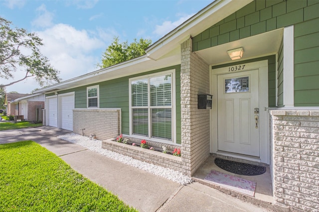 10327 Collingswood Rd, La Porte, TX 77571 - view of exterior entry with a garage, brick siding, and driveway