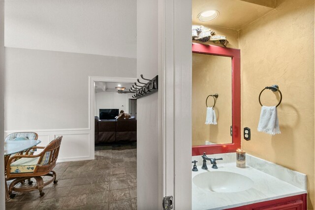 5 Hartwick Ct, Conroe, TX 77304 - bathroom featuring vanity, stone finish floors, and a wainscoted wall