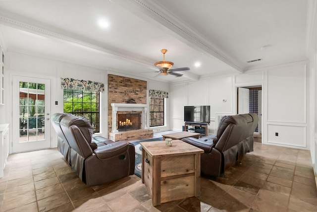 5 Hartwick Ct, Conroe, TX 77304 - living area with a decorative wall, beam ceiling, stone tile flooring, a fireplace, and a ceiling fan