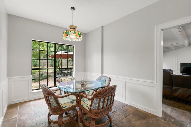 5 Hartwick Ct, Conroe, TX 77304 - dining room featuring a decorative wall, stone tile flooring, and a wainscoted wall