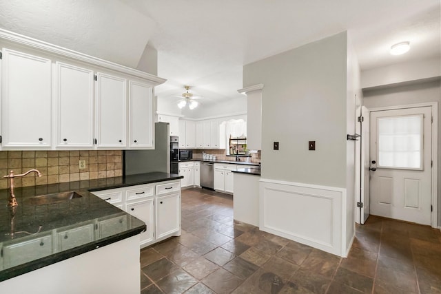 5 Hartwick Ct, Conroe, TX 77304 - kitchen with stainless steel dishwasher, ceiling fan, dark countertops, stone tile floors, and decorative backsplash