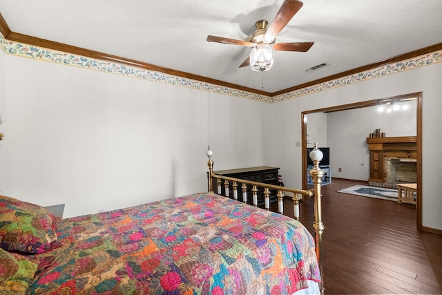 5 Hartwick Ct, Conroe, TX 77304 - bedroom with ornamental molding, wood finished floors, a fireplace, and ceiling fan