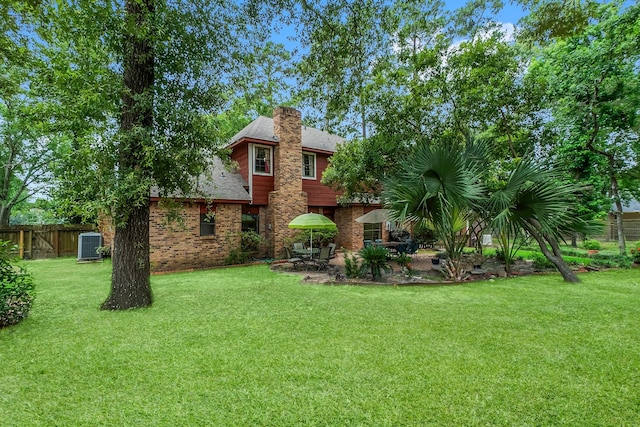 5 Hartwick Ct, Conroe, TX 77304 - rear view of property featuring a patio area, a chimney, and brick siding