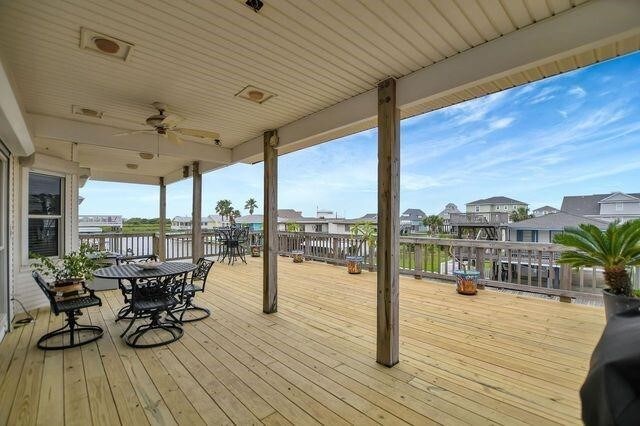 23002 Lunes St, Galveston, TX 77554 - deck with outdoor dining space, a ceiling fan, a water view, and a residential view