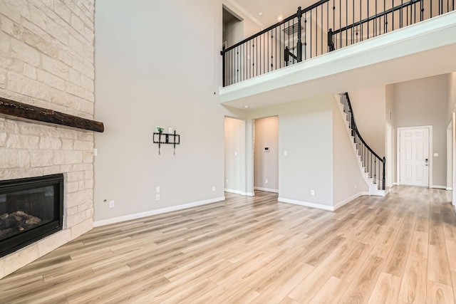 2008 Bristol Cliff Ln, Pearland, TX 77089 - unfurnished living room with a high ceiling, stairs, a large fireplace, and wood finished floors