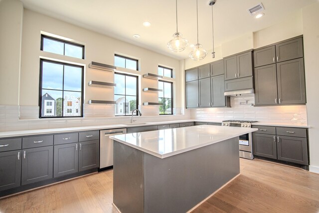 1716 Sedola Ln, Houston, TX 77055 - kitchen featuring appliances with stainless steel finishes, open shelves, light wood finished floors, tasteful backsplash, and recessed lighting