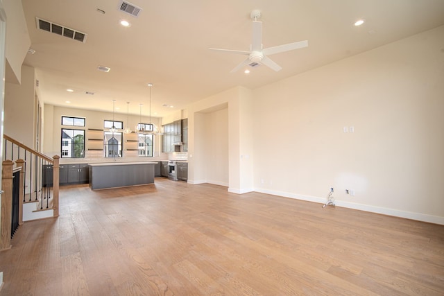 1716 Sedola Ln, Houston, TX 77055 - unfurnished living room with light wood-type flooring, a ceiling fan, stairs, and recessed lighting