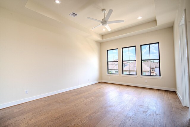 1716 Sedola Ln, Houston, TX 77055 - spare room featuring a tray ceiling, wood finished floors, a ceiling fan, and recessed lighting