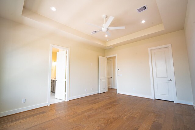 1716 Sedola Ln, Houston, TX 77055 - unfurnished bedroom with a raised ceiling, wood finished floors, recessed lighting, ensuite bath, and ceiling fan