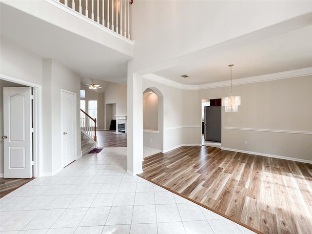 3106 Alexandros Ct, Pearland, TX 77584 - unfurnished room with stairway, a chandelier, ceiling fan, ornamental molding, and a fireplace