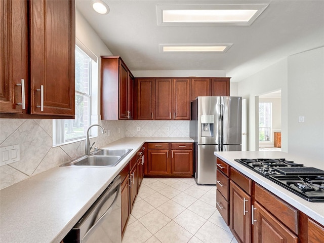 3106 Alexandros Ct, Pearland, TX 77584 - kitchen with appliances with stainless steel finishes, light countertops, tasteful backsplash, and light tile patterned floors
