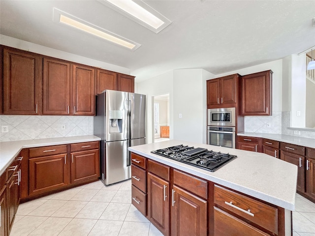 3106 Alexandros Ct, Pearland, TX 77584 - kitchen with stainless steel appliances, light countertops, backsplash, light tile patterned floors, and a kitchen island