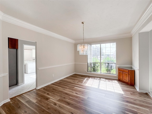 3106 Alexandros Ct, Pearland, TX 77584 - unfurnished dining area with ornamental molding, light wood finished floors, a chandelier, and washer and clothes dryer