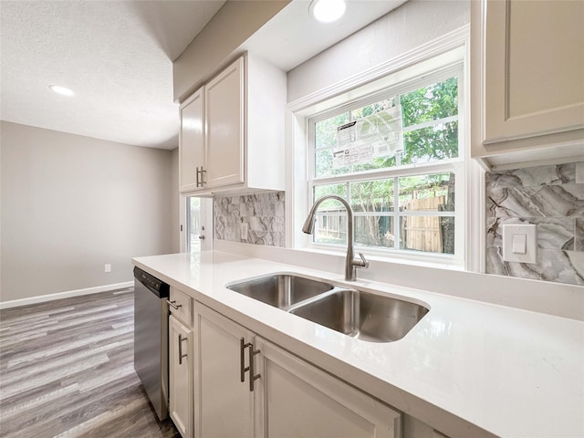 10610 Mills Prairie St, Houston, TX 77070 - kitchen with stainless steel dishwasher, tasteful backsplash, light countertops, light wood finished floors, and recessed lighting