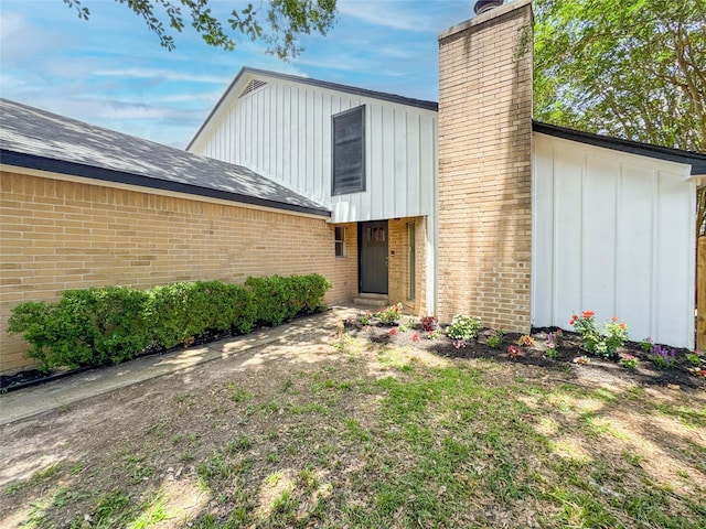 10610 Mills Prairie St, Houston, TX 77070 - view of front of home featuring board and batten siding, a chimney, and brick siding