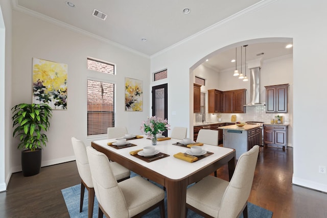 4611 Rose St, Houston, TX 77007 - dining room with dark wood-style flooring, arched walkways, ornamental molding, and recessed lighting