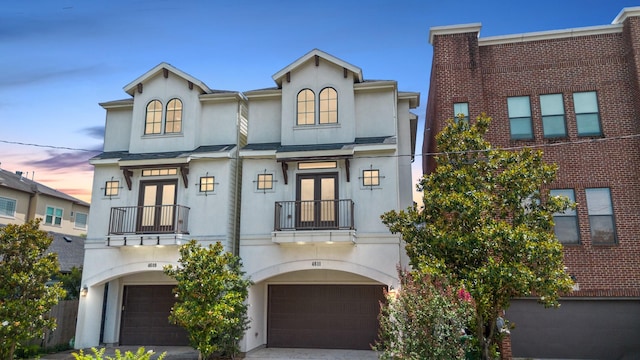 4611 Rose St, Houston, TX 77007 - view of front facade with a balcony, french doors, a garage, and stucco siding