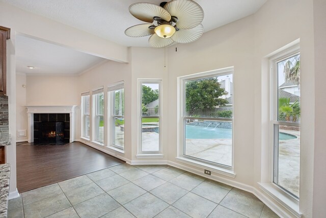 2537 La Rochelle Ct, Seabrook, TX 77586 - unfurnished living room with a ceiling fan, light tile patterned flooring, a tiled fireplace, and beam ceiling
