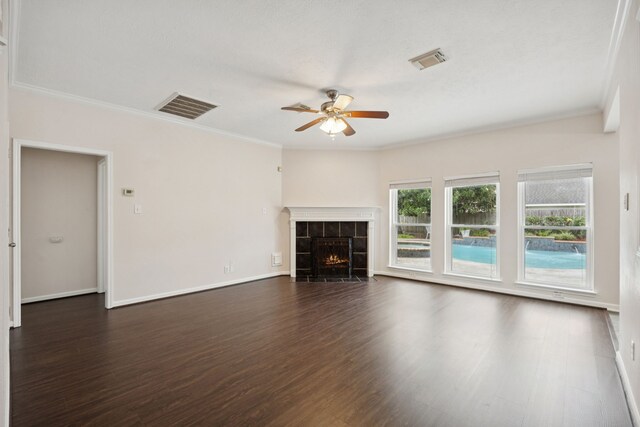 2537 La Rochelle Ct, Seabrook, TX 77586 - unfurnished living room featuring ceiling fan, crown molding, dark wood finished floors, and a tile fireplace