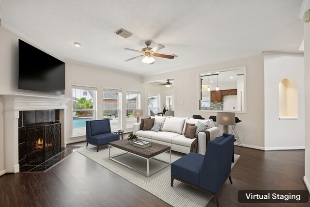 2537 La Rochelle Ct, Seabrook, TX 77586 - living room featuring a ceiling fan, a fireplace, wood finished floors, and crown molding