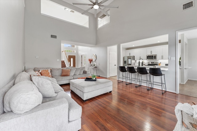 4318 Raintree Ct, Pasadena, TX 77505 - living room featuring ceiling fan, dark wood-style floors, a high ceiling, and stairway
