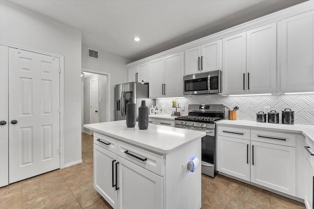 4318 Raintree Ct, Pasadena, TX 77505 - kitchen with appliances with stainless steel finishes, decorative backsplash, recessed lighting, white cabinets, and a kitchen island