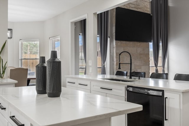 4318 Raintree Ct, Pasadena, TX 77505 - kitchen featuring black dishwasher, a kitchen island, light stone countertops, and white cabinets