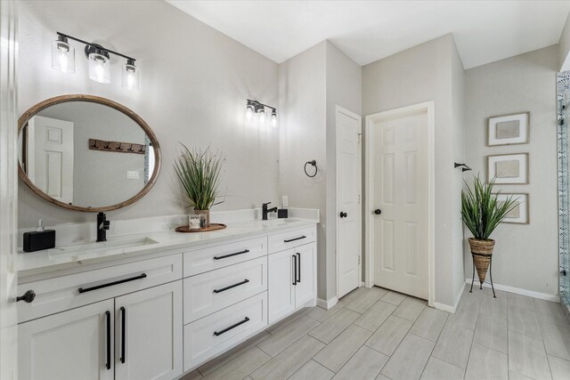 4318 Raintree Ct, Pasadena, TX 77505 - bathroom featuring double vanity and baseboards