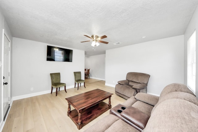2811 Wentworth Ln, Pasadena, TX 77506 - living room with light wood finished floors, ceiling fan, a textured ceiling, and plenty of natural light