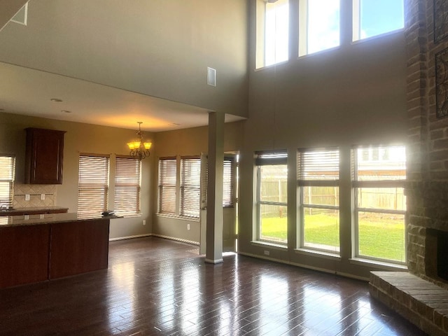 8303 Kerrington Glen Dr, Cypress, TX 77433 - unfurnished living room with a chandelier, dark wood-type flooring, a fireplace, and a high ceiling
