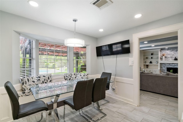 15514 Pebble Bend Dr, Houston, TX 77068 - dining area featuring built in features, recessed lighting, a fireplace, and a decorative wall