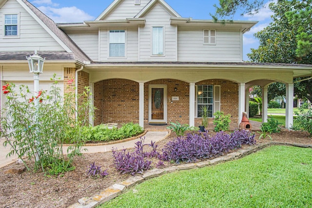 8806 Aberdeen Oaks Dr, Houston, TX 77095 - view of front facade with brick siding, covered porch, and a front yard