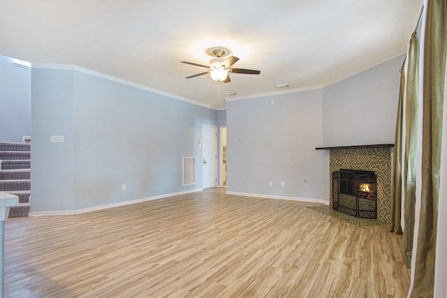 8806 Aberdeen Oaks Dr, Houston, TX 77095 - unfurnished living room with light wood finished floors, ceiling fan, a tiled fireplace, stairs, and crown molding