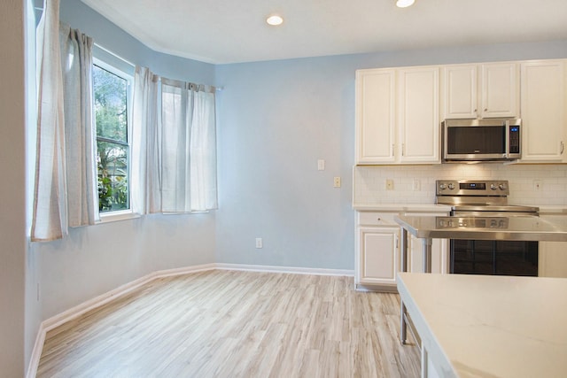 8806 Aberdeen Oaks Dr, Houston, TX 77095 - kitchen with stainless steel appliances, light wood-style floors, decorative backsplash, white cabinets, and light countertops