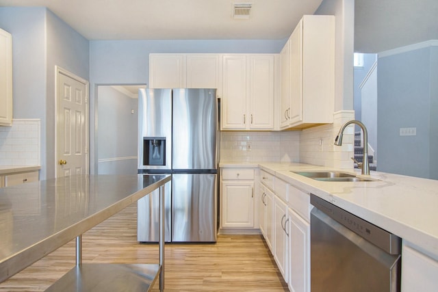 8806 Aberdeen Oaks Dr, Houston, TX 77095 - kitchen with stainless steel appliances, light wood finished floors, white cabinets, light stone counters, and backsplash