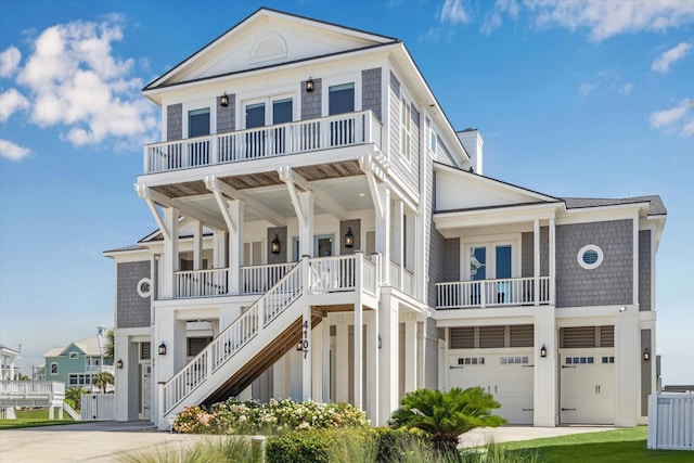 4107 Bluewing Teal Ct, Galveston, TX 77554 - coastal inspired home with stairs, a balcony, a garage, and covered porch