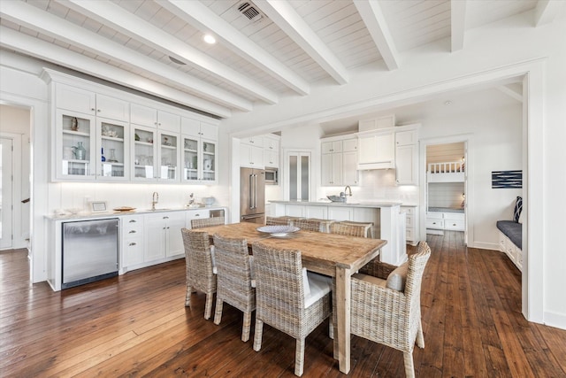 4107 Bluewing Teal Ct, Galveston, TX 77554 - dining space featuring beverage cooler, dark wood finished floors, wet bar, and a wood ceiling with exposed beams