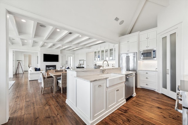 4107 Bluewing Teal Ct, Galveston, TX 77554 - kitchen featuring appliances with stainless steel finishes, beamed ceiling, dark wood finished floors, white cabinetry, and light stone countertops