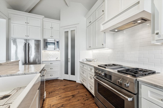 4107 Bluewing Teal Ct, Galveston, TX 77554 - kitchen featuring high quality appliances, custom range hood, decorative backsplash, dark wood-type flooring, and white cabinetry