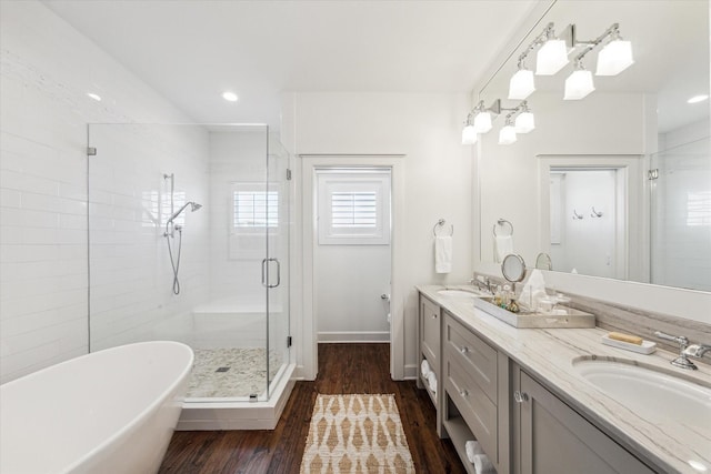 4107 Bluewing Teal Ct, Galveston, TX 77554 - bathroom with a shower stall, double vanity, a soaking tub, wood finished floors, and recessed lighting