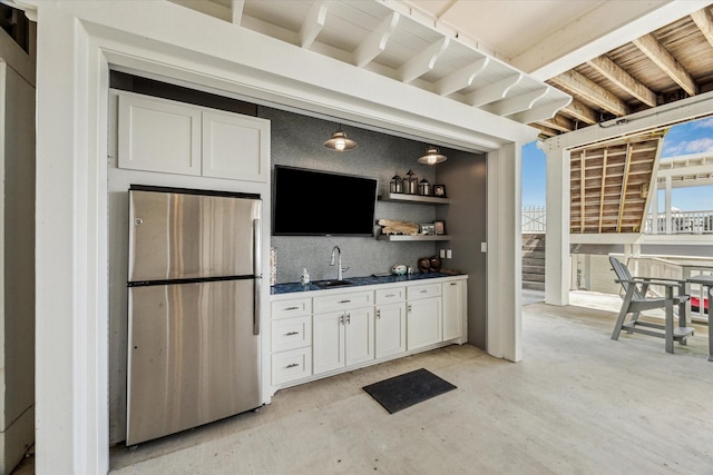 4107 Bluewing Teal Ct, Galveston, TX 77554 - indoor wet bar featuring freestanding refrigerator, backsplash, concrete floors, and stairs