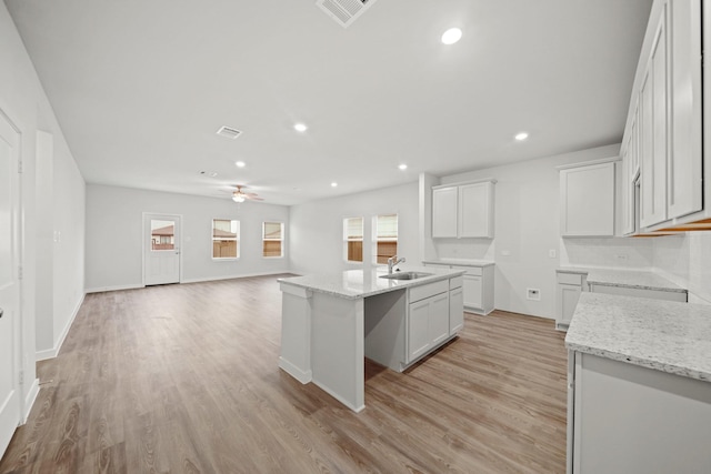 319 Bennett St, Angleton, TX 77515 - kitchen featuring ceiling fan, light wood-type flooring, light stone countertops, open floor plan, and recessed lighting