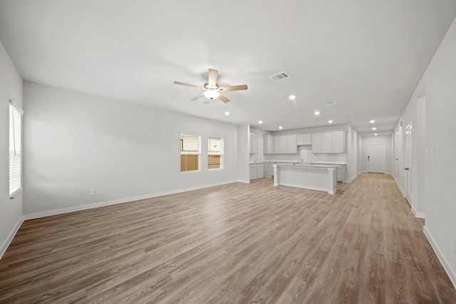 319 Bennett St, Angleton, TX 77515 - unfurnished living room featuring a ceiling fan, recessed lighting, and light wood finished floors